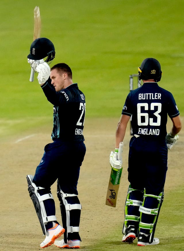 Jason Roy (left) raises his bat and helmet after reaching a century