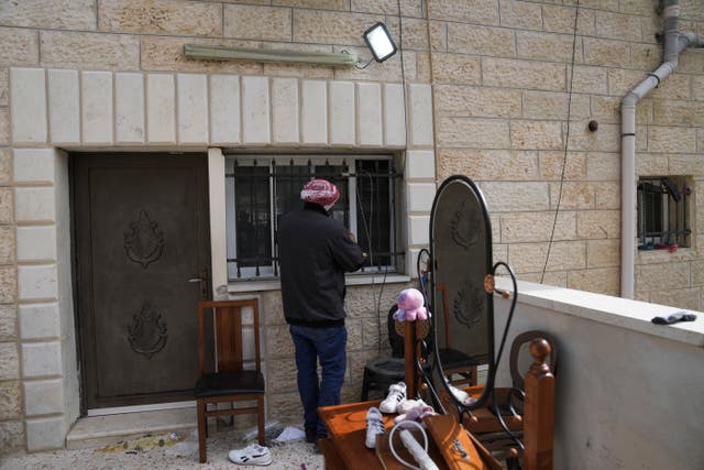A Palestinian man looks at the sealed-off family home of Khaire Alkam