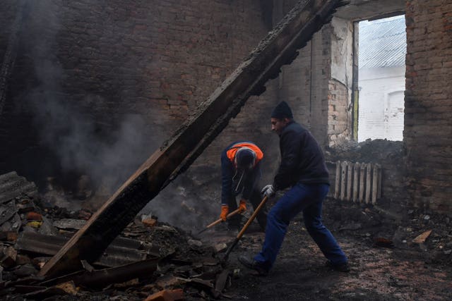 Workers clean up a school that was damaged from Russian shelling in the town of Orekhovo in the Zaporizhzhya region of Ukraine