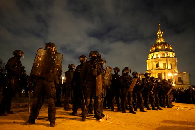 Riot police officers take position near the Invalides monument after a demonstration against plans to push back France’s retirement age in Paris