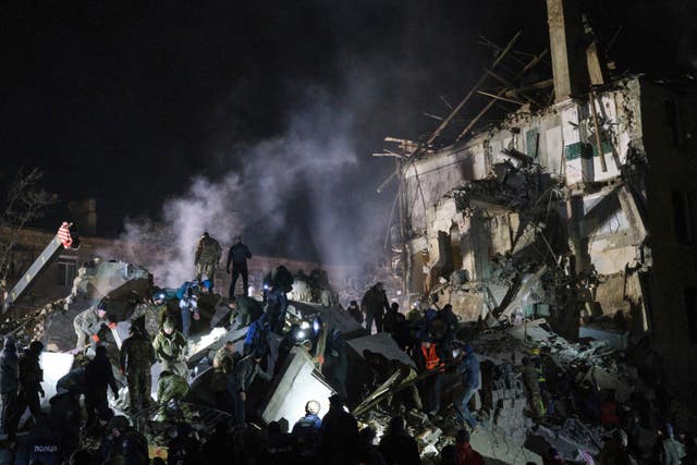 Emergency workers and local residents clear the rubble after a Russian rocket hit an apartment building in Kramatorsk, Ukraine, on Thursday