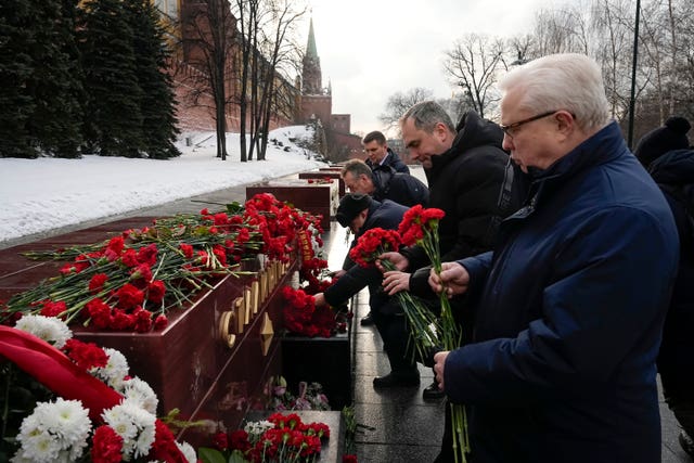 People lay flowers at the Tomb Stalingrad during a wreath-laying ceremony at the Tomb of the Unknown Soldier near the Kremlin Wall