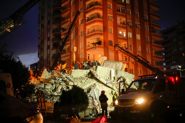 Rescuers search for people in a destroyed building in Adana, Turkey