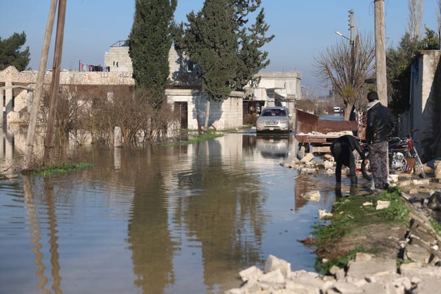 A car drives through a village in Syria which flooded after the  earthquake