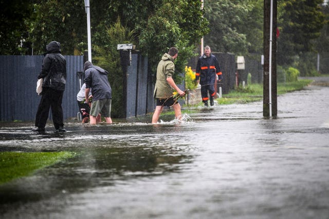 People walk through flood water in Hastings, southeast of Auckland