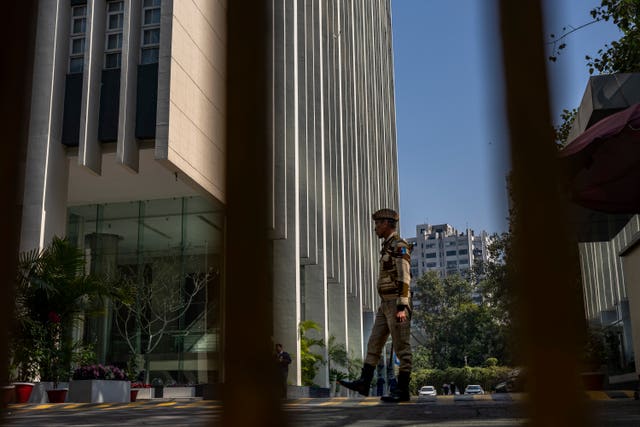 An armed security person stands guard at the gate of a building housing BBC offices in New Delhi, India, on February 15