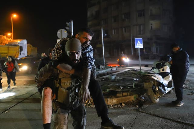 A soldier carries a man after being injured in the latest earthquake in Hatay, Turkey
