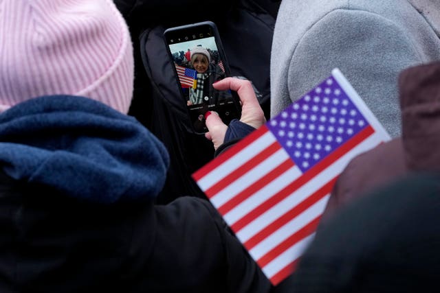 A woman takes a selfie while waiting for the speech of US President Joe Biden near the Royal Castle in Warsaw