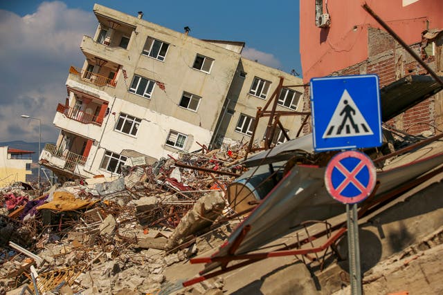A destroyed building leans on a neighbouring house following the earthquake in Samandag, southern Turkey