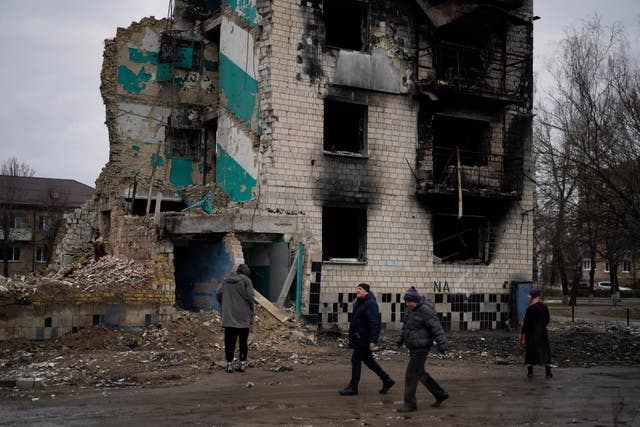 People walk among destroyed buildings in Borodyanka, north of Kyiv, Ukraine