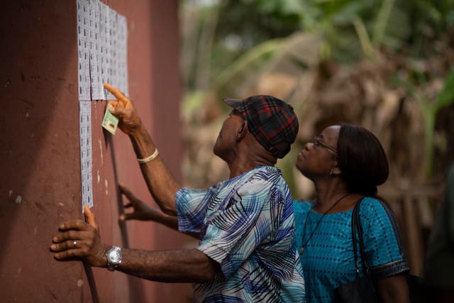 People check for their names on the voters registration list during the presidential elections in Agulu, Nigeria