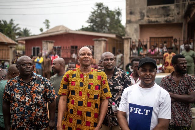Supporters of Labour Party candidate Peter Obi wait outside a polling station to greet him in Agulu