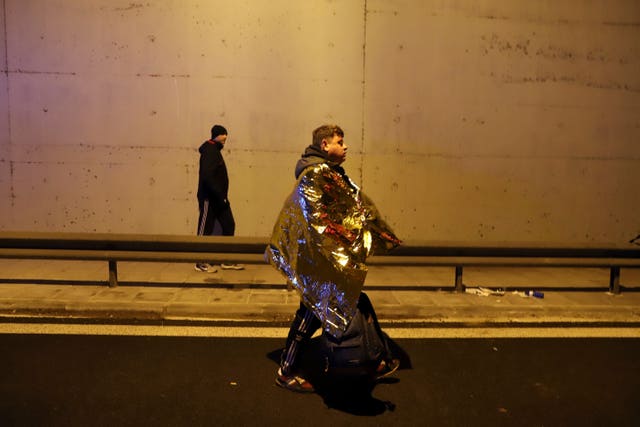 A passenger walks on a road after a train collision in Larissa city, Greece 