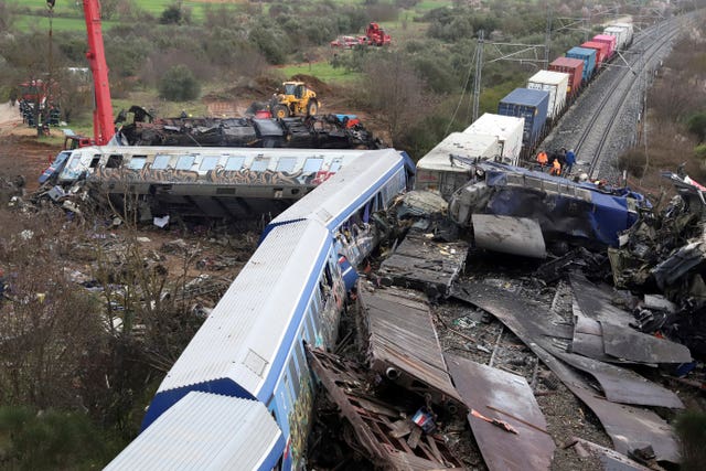 Firefighters and rescuers at the scene of a rail crash in Greece that killed 57 people