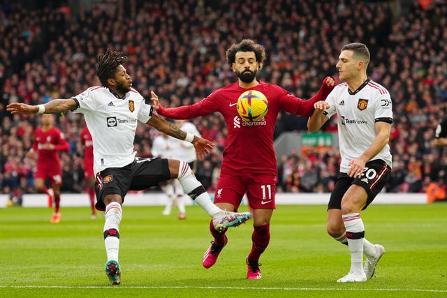 Liverpool’s Mohamed Salah, centre, tries to hold off Manchester United’s Diogo Dalot, right, and Fred during a Premier League match
