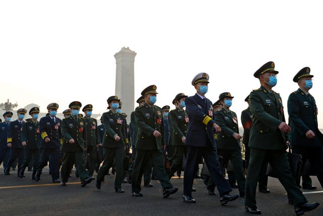 Military delegates wearing face masks march by Tiananmen Square as they arrive to attend the opening session of China’s National People’s Congress (NPC) (Cao Can/AP)