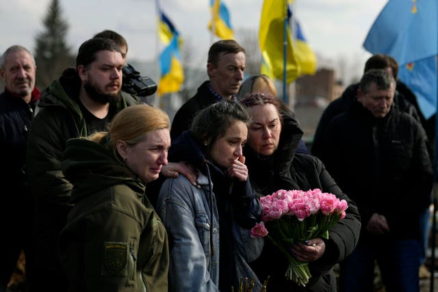 Mourners gather next to the body of Ms Rikhlitska