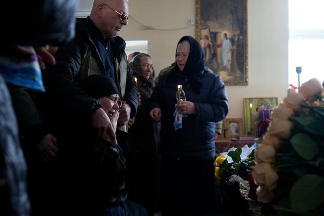 Olena Rikhlitska, second right, mother of Yana Rikhlitska cries during the funeral