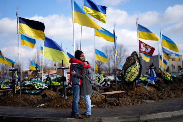 Mourners hug each other during the funeral of Yana Rikhlitska, a Ukrainian army medic killed in the Bakhmut area of Ukraine