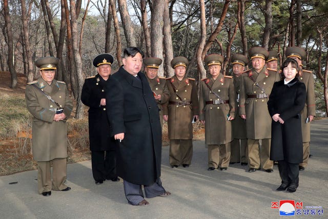 North Korean leader Kim Jong Un, with his daughter, provides guidance to military officials at an undisclosed location