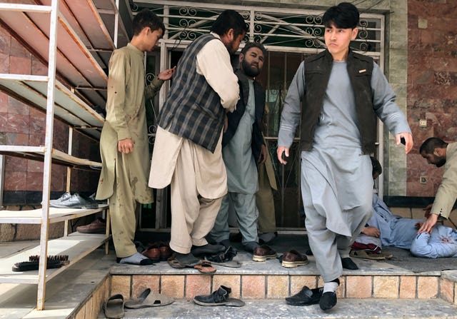 An injured man, right, is treated after a bomb blast in Mazar-e-Sharif