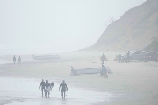 Two boats, one overturned, sit on Black's Beach in San Diego 