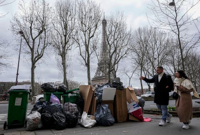 People walk past uncollected rubbish near the Eiffel Tower in Paris 