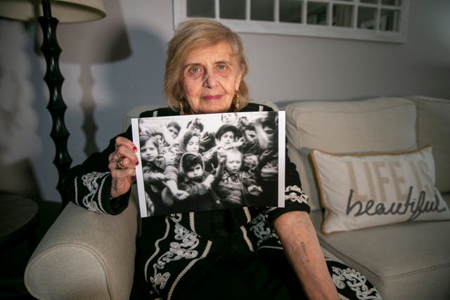 Ms Friedman holds out her left arm to show the number the Nazis tattooed while holding a photo of her as a six-year-old, on the left in the picture, holding out the same arm to show the tattoo to the camera in 1945 after the Soviet military liberated Auschwitz concentration camp