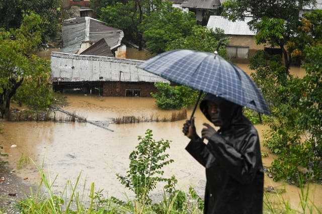 A man passes houses that are submerged in flood waters in Blantyre, Malawi