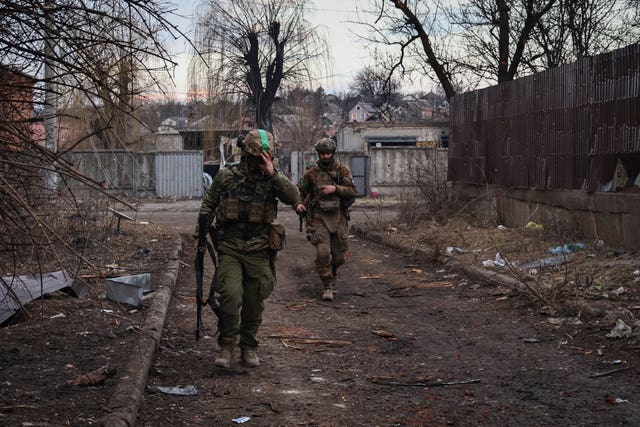 Ukrainian soldiers walk along a street in the area of the heaviest battles with Russian forces in Bakhmut, Ukraine