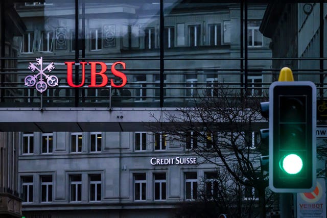 A traffic light signals green in front of the logos of the Swiss banks Credit Suisse and UBS in Zurich