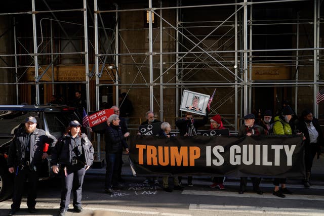 People protest in front of the District Attorney office ahead of former President Donald Trump’s anticipated indictment on Tuesday