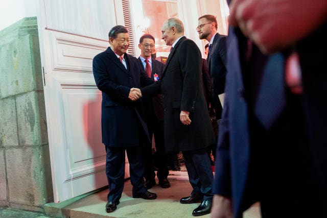 The Chinese president shakes hands with the Russian president as he leaves after their dinner in the Kremlin 