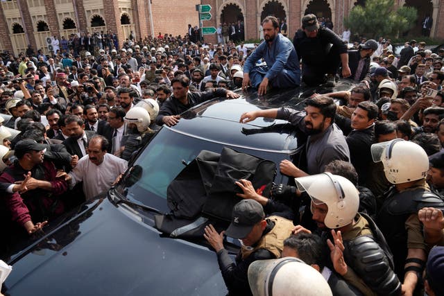 Police make way for a vehicle carrying Mr Khan