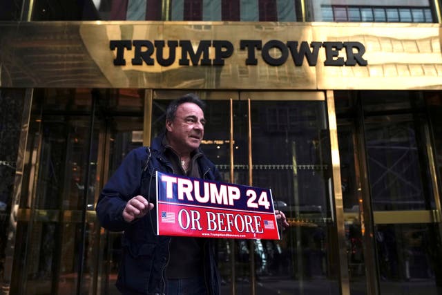 Jeffrey Shinko, of Lucerne County, Pa, holds a sign while standing in front Trump Tower on Tuesday, March 21, 2023, in New York