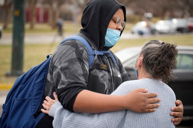 A student hugs a woman as they are reunited after the shooting