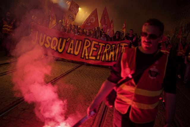 Railway workers hold a banner reading ‘Until withdrawal’ during a demonstration in Lyon on Wednesday