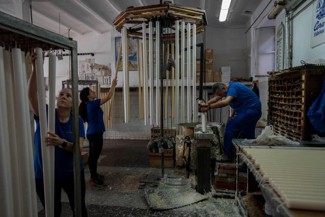 Los empleados trabajan en la fábrica de velas Bellito en Andujar, sur de España
