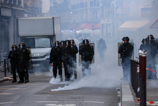 Riot police face protesters during a rally in Paris