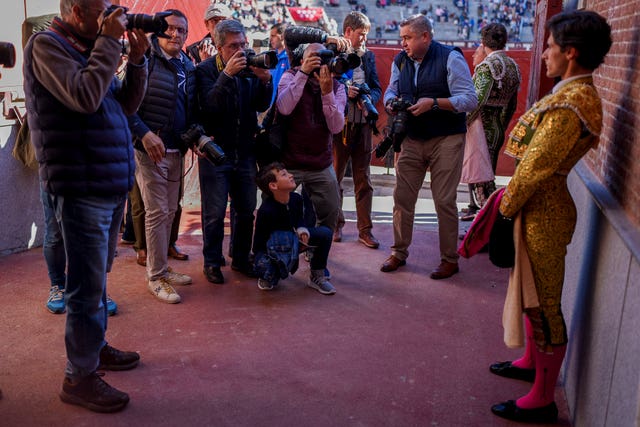 Photographers take pictures of Spanish bullfighter Alvaro Alarcon, right, before a bullfight with young bulls at Las Ventas bullring in Madrid, Spain