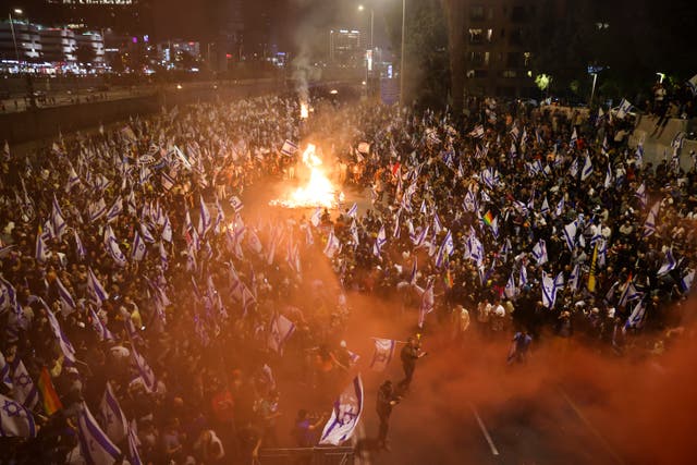 Israelis opposed to Prime Minister Benjamin Netanyahu’s judicial overhaul plan set up bonfires and block a motorway during a protest moments after the Israeli leader fired his defence minister, in Tel Aviv, Israel