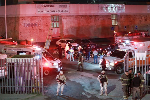 Paramedics and security forces work amid the covered bodies of migrants who died in the fire at the immigration detention centre in Ciudad Juarez, Mexico 