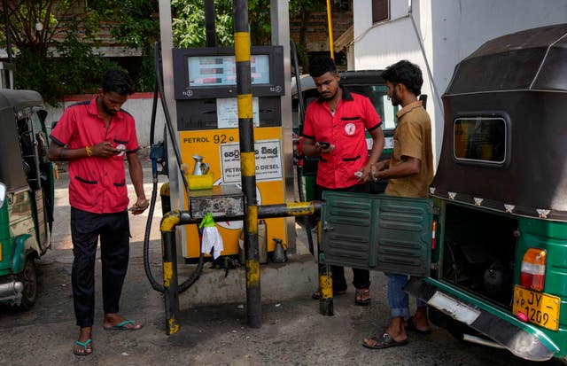 Workers fill vehicles at a petrol station in Colombo 