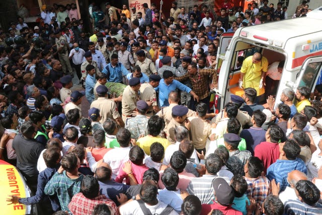 An accident victim is carried towards a waiting ambulance