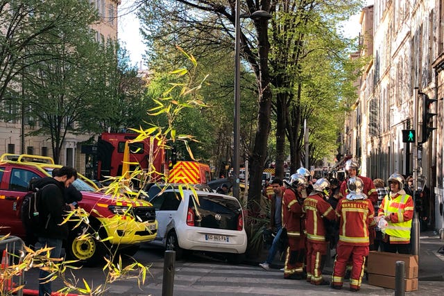 Firefighters gather near the street where a building collapsed in Marseille, southern France