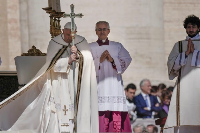 Pope Francis, left, stands on the altar in St Peter’s Square at the Vatican during the Easter Sunday Mass