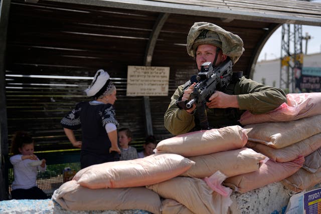 An Israeli soldier guards a march to the outpost of Eviatar
