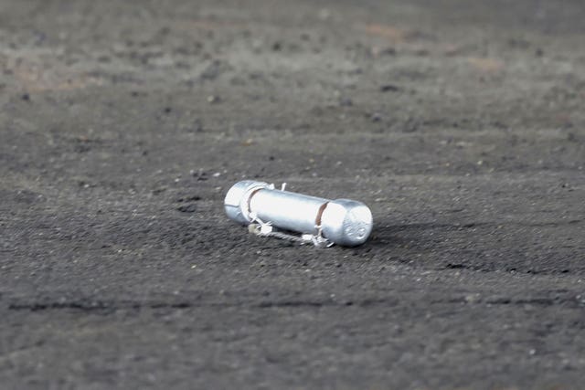 A suspicious object is seen on the ground where a suspect was arrested