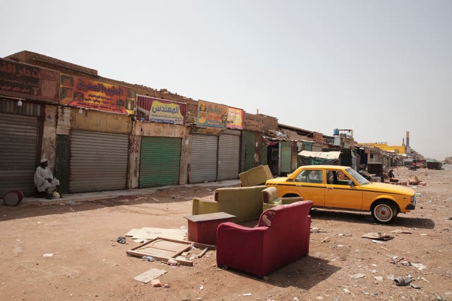 A man sits by shuttered shops in Khartoum, Sudan