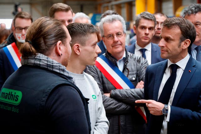 French President Emmanuel Macron, right, talks to employees during a visit to Mathis, a company specialising in large wooden buildings, in Muttersholtz, eastern France 